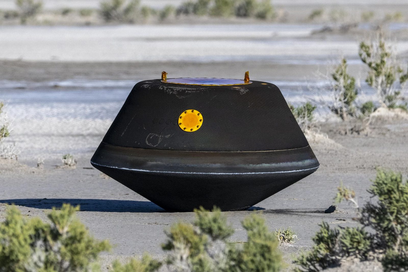 The OSIRIS-REx sample return capsule resting on the desert floor in Utah after landing