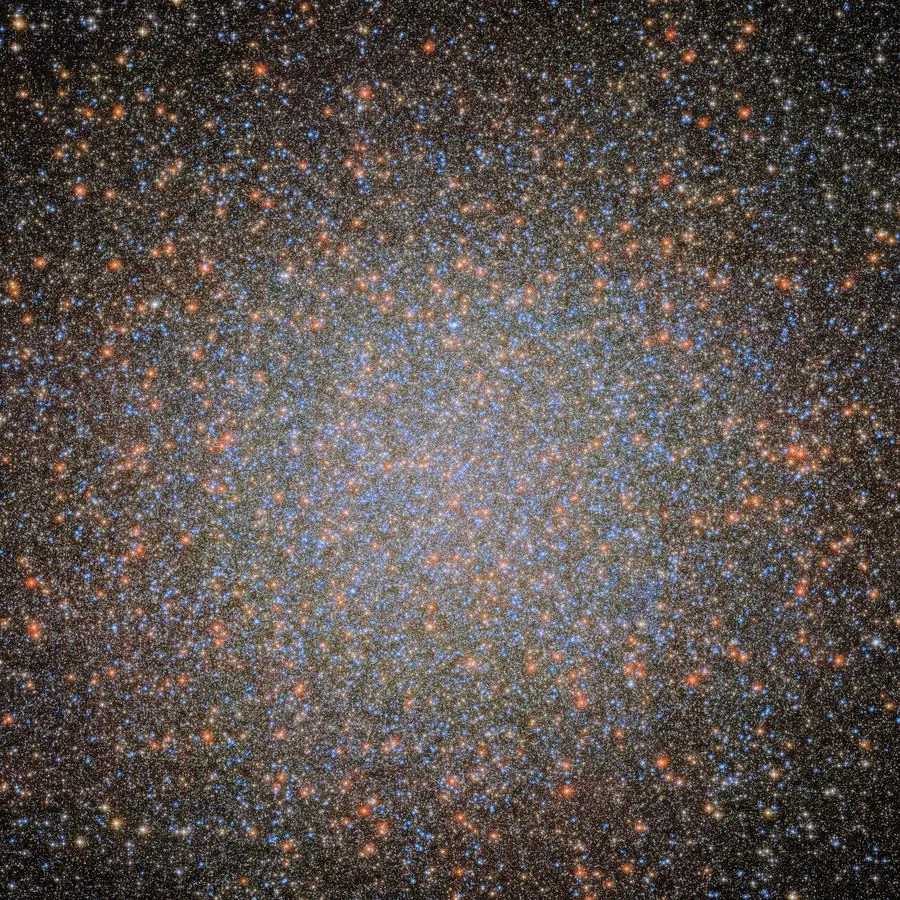 A dense ball of millions of blue and orange stars, crowding together towards a bright centre