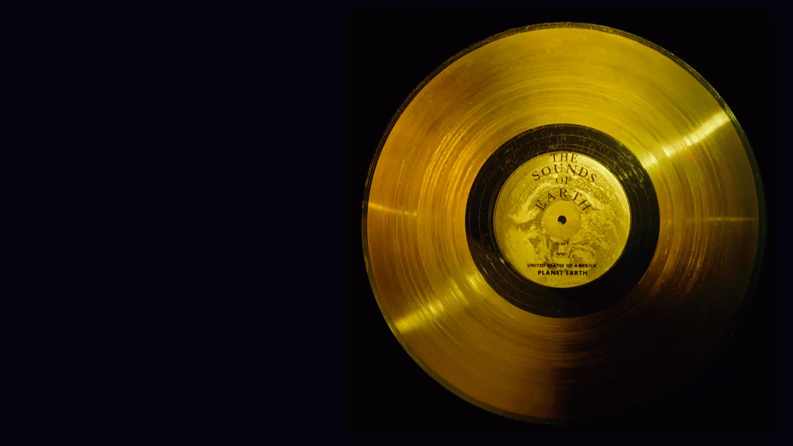 The gold-plated Voyager record, labelled The Sounds of Earth, against a black background