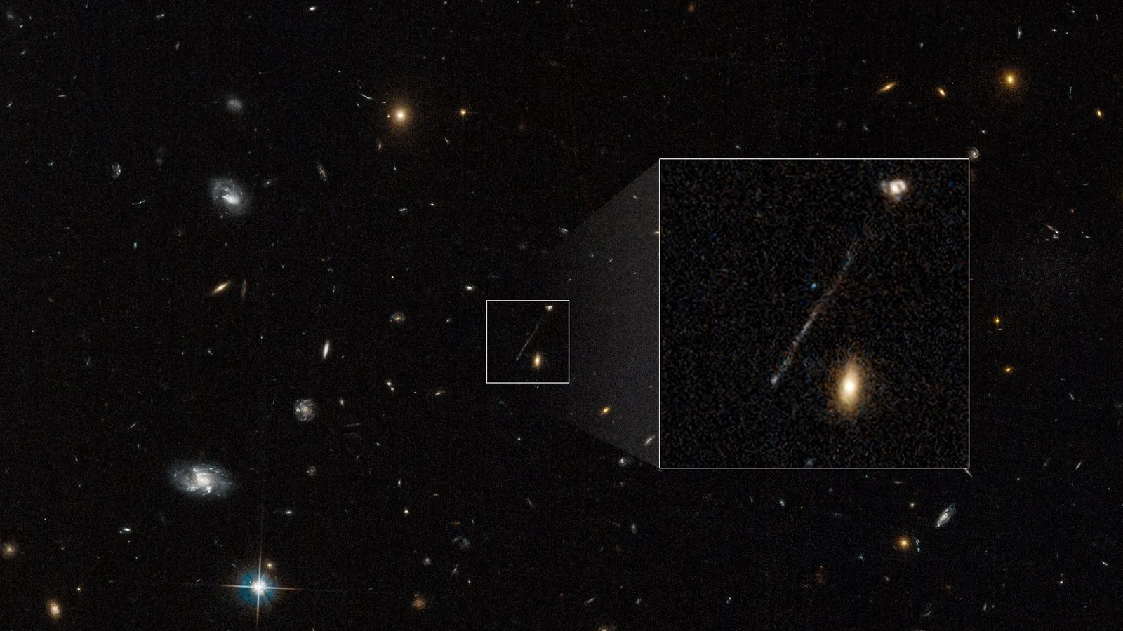 A Hubble field of distant galaxies with a small box around a faint diagonal streak, shown enlarged in a second box: a thin line of light leading from a small galaxy